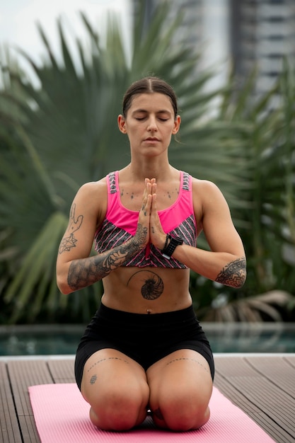 Kostenloses Foto vorderansicht der frau, die yogaübungen macht