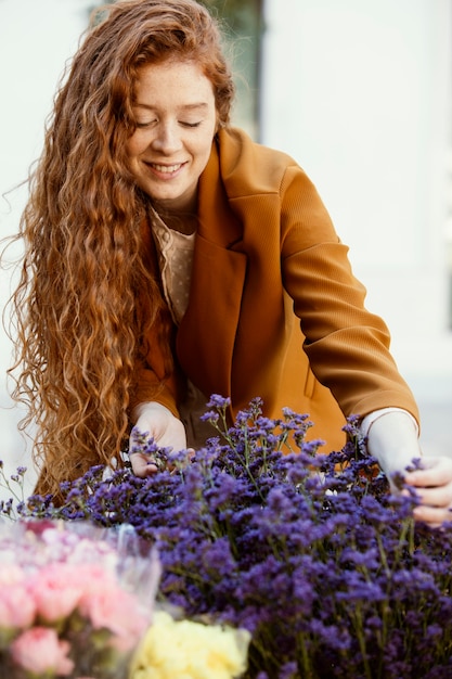 Vorderansicht der Frau draußen im Frühjahr mit Blumenstrauß