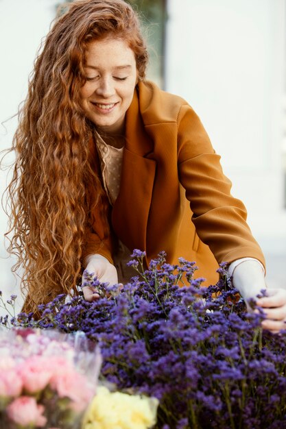 Vorderansicht der Frau draußen im Frühjahr mit Blumenstrauß