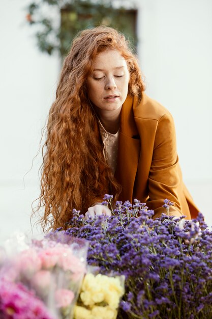 Vorderansicht der Frau draußen mit Strauß der Frühlingsblumen