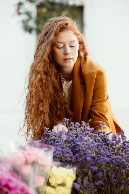 Vorderansicht der Frau draußen mit Strauß der Frühlingsblumen