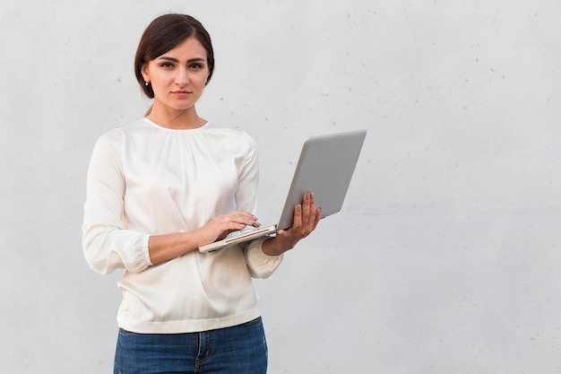 Vorderansicht der Geschäftsfrau, die Laptop draußen hält