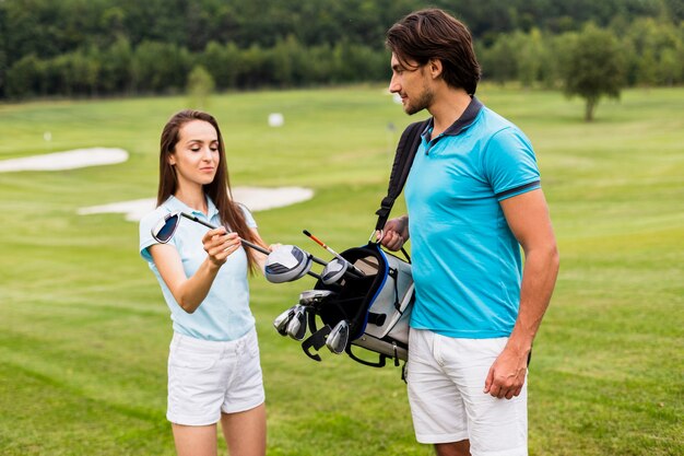 Vorderansicht der Golfspieler, die einen Verein betrachten