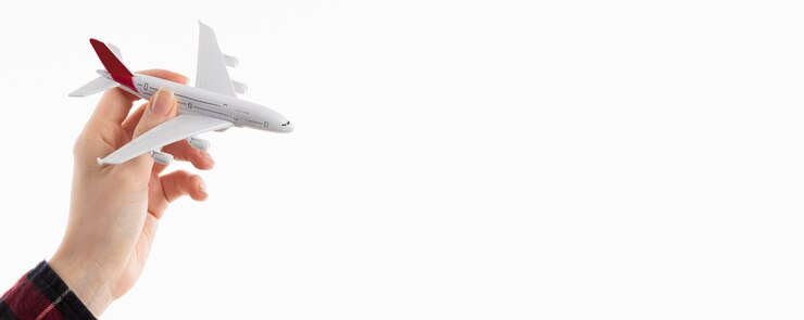 Kostenlose Foto vorderansicht der hand, die flugzeugfigur mit kopienraum hält