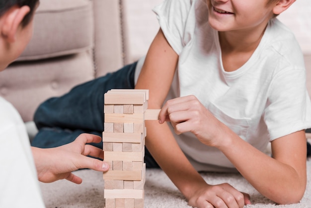 Kostenloses Foto vorderansicht der jungen, die ein spiel auf fußboden spielen