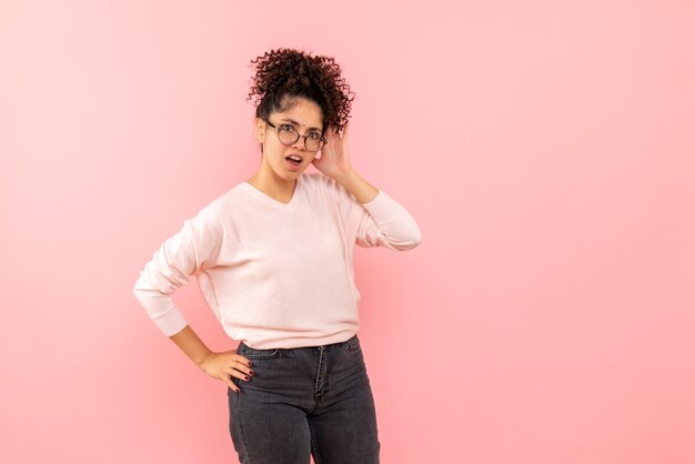 Vorderansicht der jungen Frau an der rosa Wand