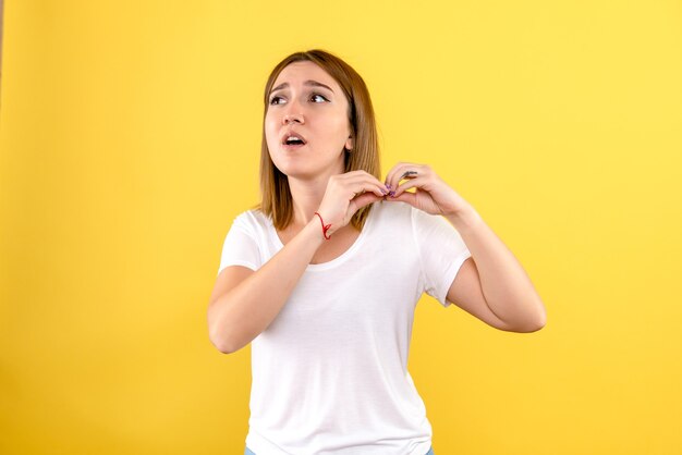 Vorderansicht der jungen Frau auf gelber Wand