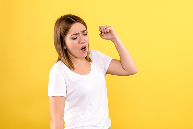 Vorderansicht der jungen Frau auf gelber Wand