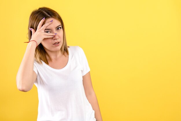 Vorderansicht der jungen Frau auf gelber Wand