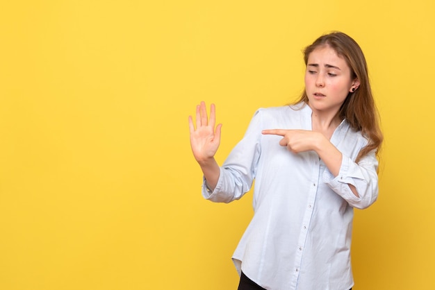 Vorderansicht der jungen Frau, die auf ihre Handfläche zeigt