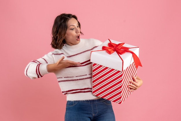 Vorderansicht der jungen Frau mit Weihnachten an der rosa Wand