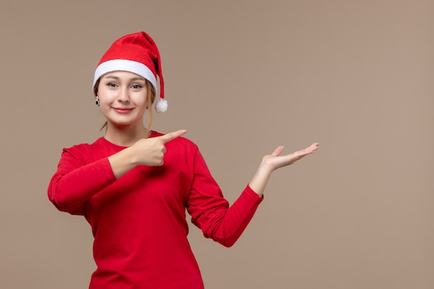 Vorderansicht der jungen Frau mit Weihnachtsumhang auf Braun