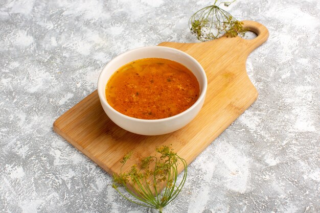 Vorderansicht der köstlichen Suppe innerhalb des Tellers auf dem Graulichtschreibtisch