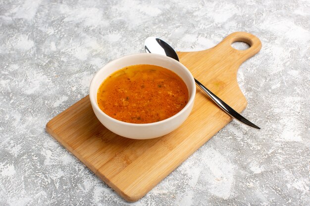 Vorderansicht der köstlichen Suppe innerhalb des Tellers auf dem Graulichtschreibtisch