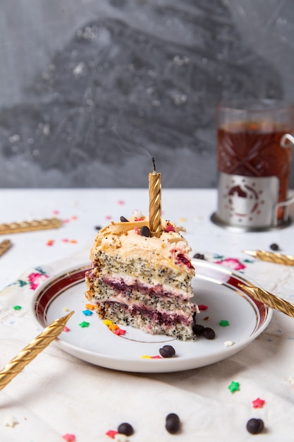 Vorderansicht der Kuchenscheibe innerhalb Platte mit Kerzentee und kleinen Sternzeichen auf der hellen Oberfläche