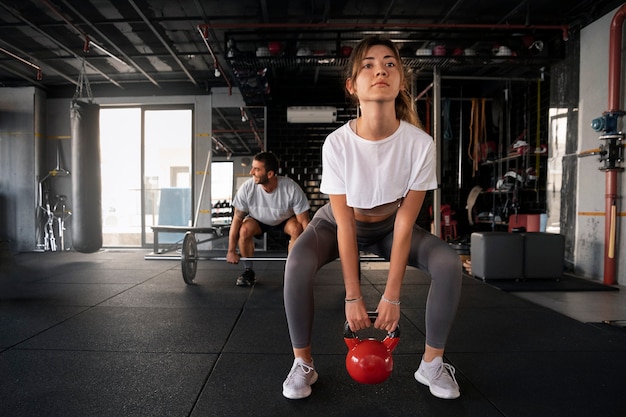 Kostenloses Foto vorderansicht der leute, die gemeinsam im fitnessstudio trainieren