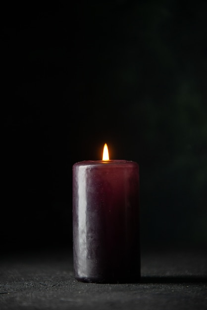 Vorderansicht der lila Kerze auf Dunkelheit