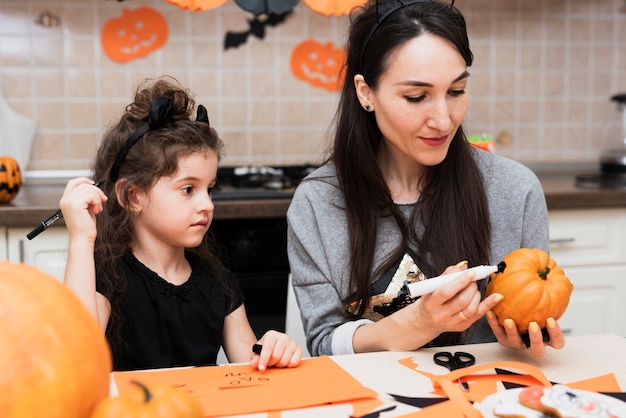 Vorderansicht der Mutter und der Tochter mit Kürbis