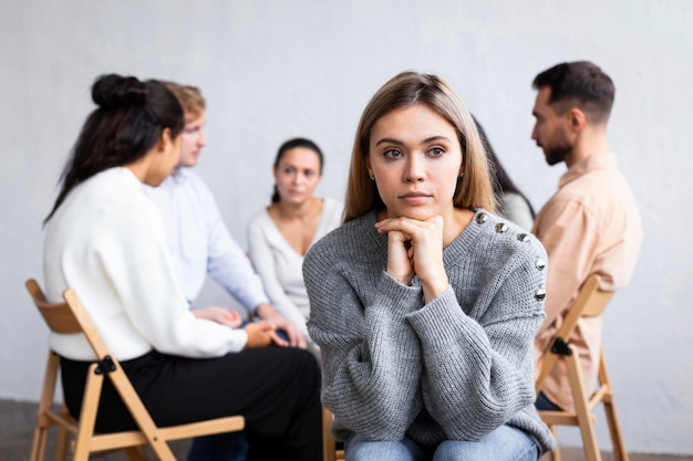 Vorderansicht der nachdenklichen Frau bei einer Gruppentherapiesitzung