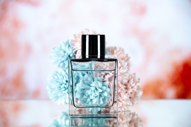 Vorderansicht der Parfümflasche und Blumen auf beige unscharfem Hintergrund