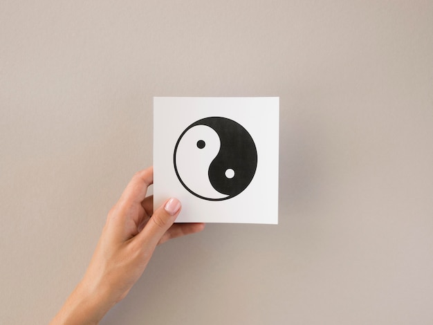 Vorderansicht der Person, die Ying und Yang Symbol hält