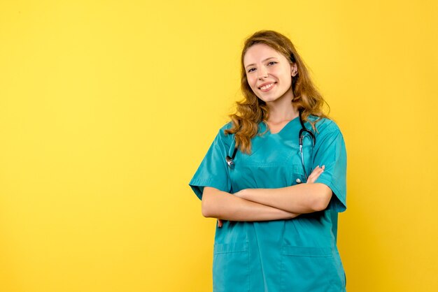 Vorderansicht der Ärztin, die auf gelber Wand lächelt