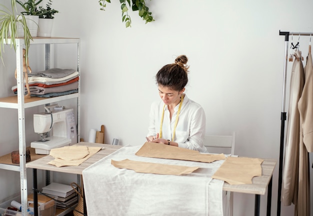 Kostenloses Foto vorderansicht der schneiderin, die im studio arbeitet