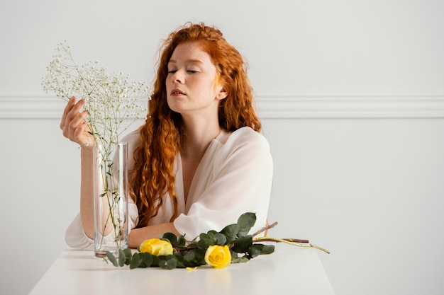 Vorderansicht der schönen Frau, die mit Frühlingsblumen aufwirft