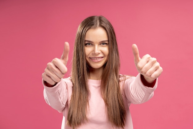 Vorderansicht der Smiley-Frau, die Daumen aufgibt