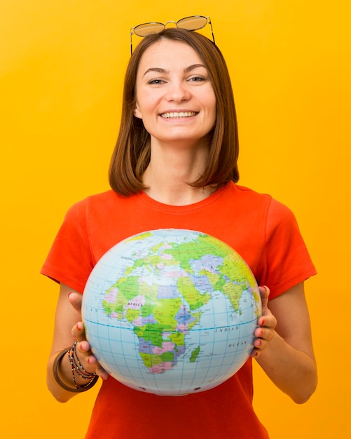 Kostenloses Foto vorderansicht der smiley-frau, die globus hält