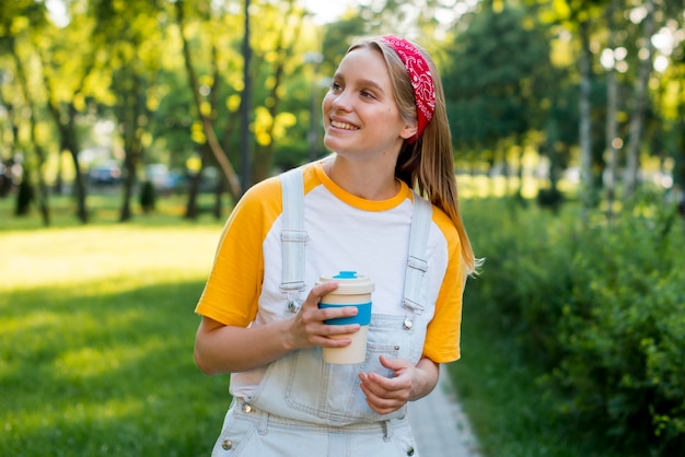 Vorderansicht der Smileyfrau draußen mit Tasse