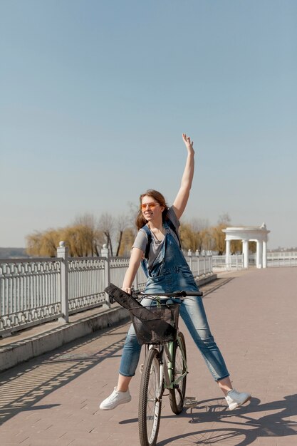 Vorderansicht der sorglosen Frau, die ein Fahrrad reitet