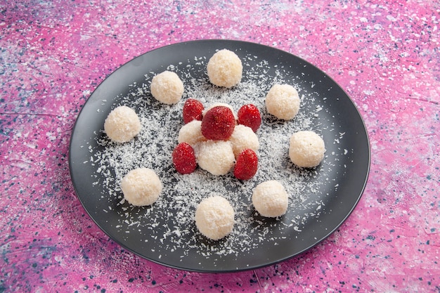 Kostenloses Foto vorderansicht der süßen kugeln der köstlichen kokosnussbonbons auf rosa wand