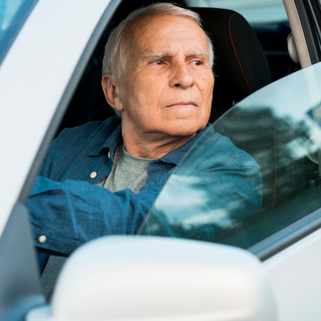 Vorderansicht des alten Mannes im persönlichen Auto