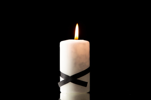 Vorderansicht des Anzündens einer Kerze auf Schwarz