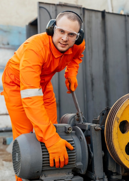 Vorderansicht des Arbeiters mit Kopfhörern und Schutzbrille