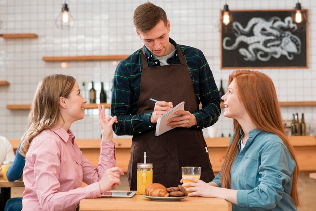 Vorderansicht des Barista, der eine Bestellung entgegennimmt