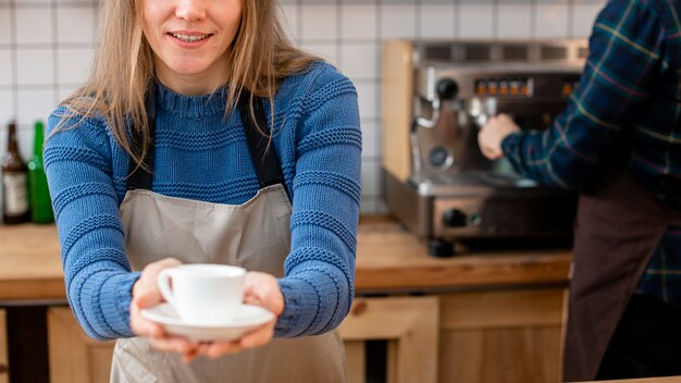 Vorderansicht des Barista, der Kaffee hält