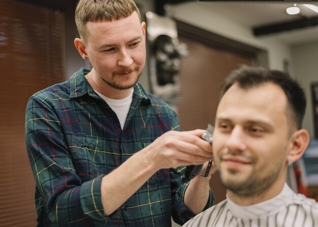 Vorderansicht des Haarstilyst, der einen Haarschnitt gibt