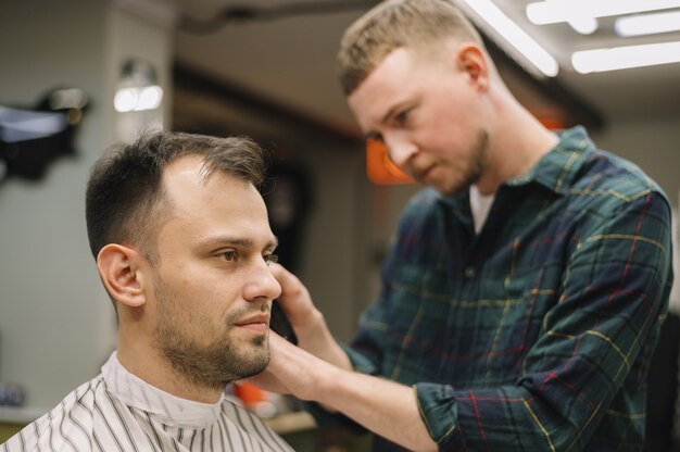 Vorderansicht des Haarstilyst, der einen Haarschnitt gibt