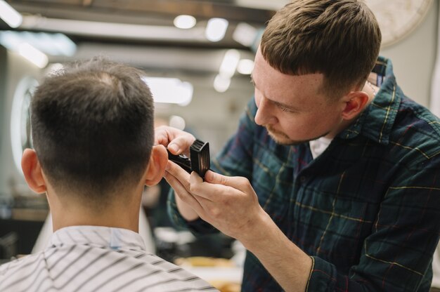 Vorderansicht des Haarstilyst, der einen Haarschnitt gibt