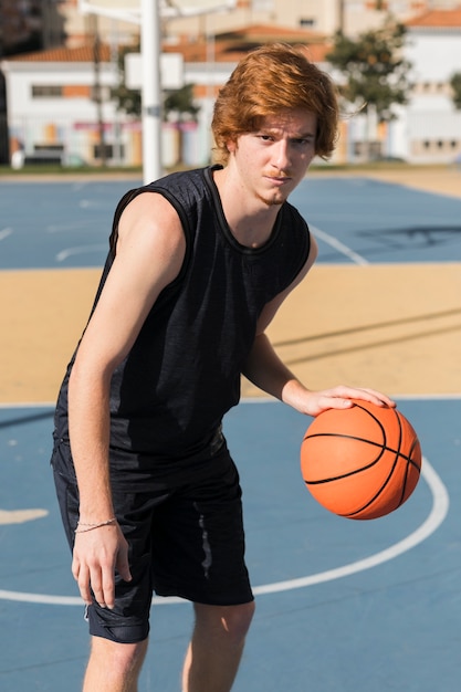 Vorderansicht des Jungen, der Basketball spielt