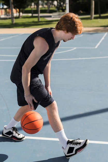 Vorderansicht des Jungen, der Basketball spielt