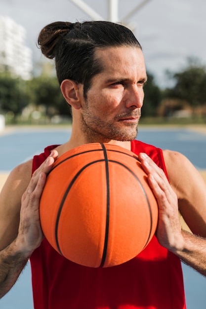 Vorderansicht des Jungen, der einen Basketballball hält