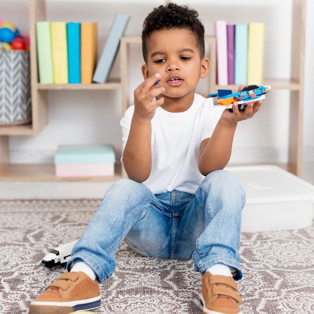 Vorderansicht des Jungen, der mit Spielzeug spielt