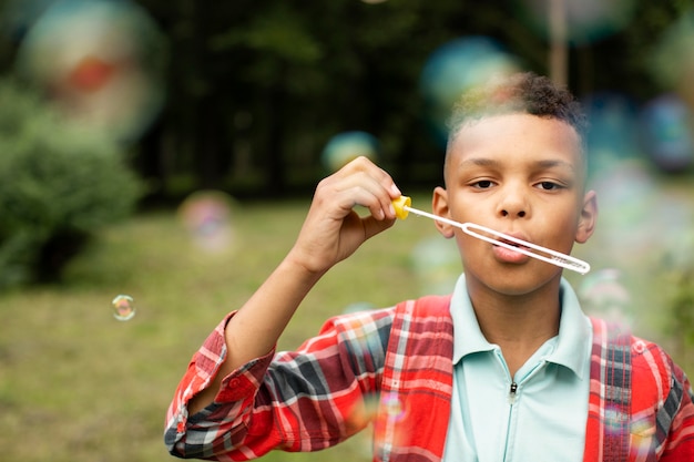 Vorderansicht des Jungen, der Seifenblasen macht