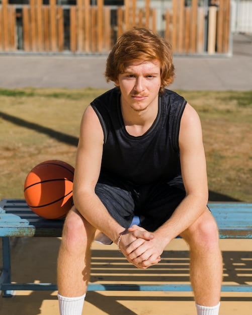 Kostenloses Foto vorderansicht des jungen mit basketballball