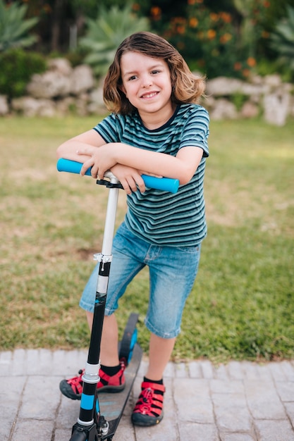 Kostenloses Foto vorderansicht des jungen mit roller