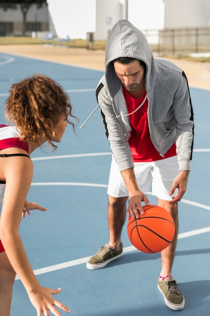 Vorderansicht des Jungen und des Mädchens, die Basketball spielen