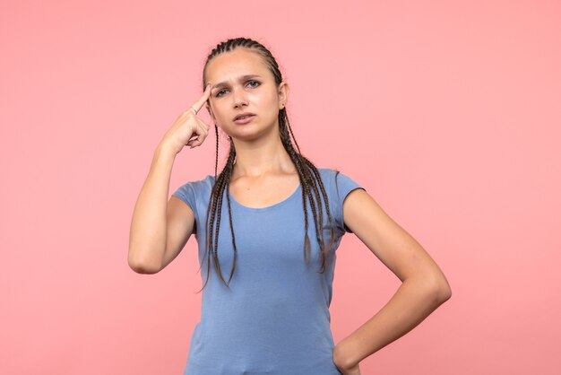 Vorderansicht des jungen weiblichen Denkens auf rosa